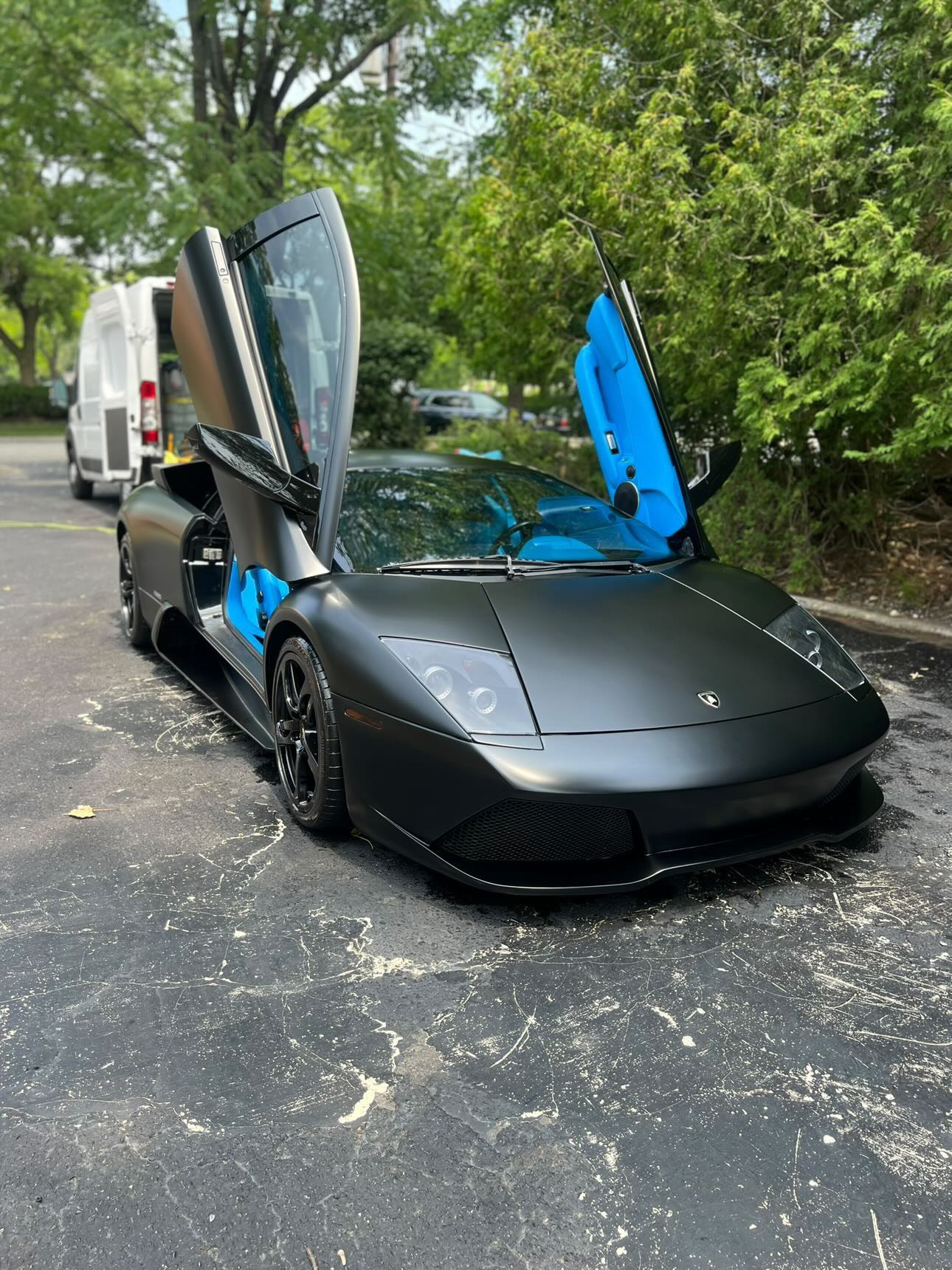 Matte black Lamborghini Murciélago with scissor doors open and custom blue interior, serviced by M3 after hours